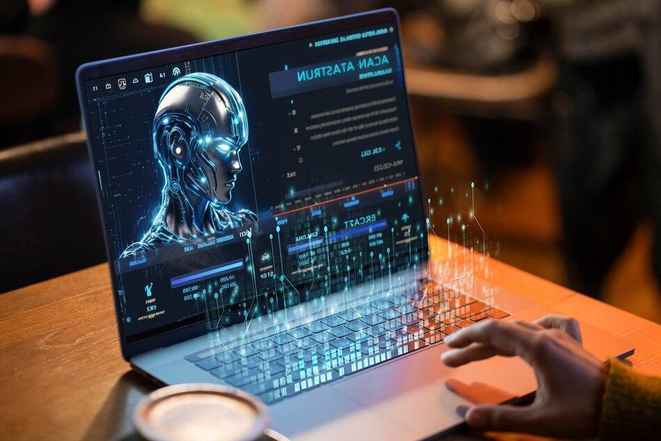 person using a laptop displaying a holographic AI interface